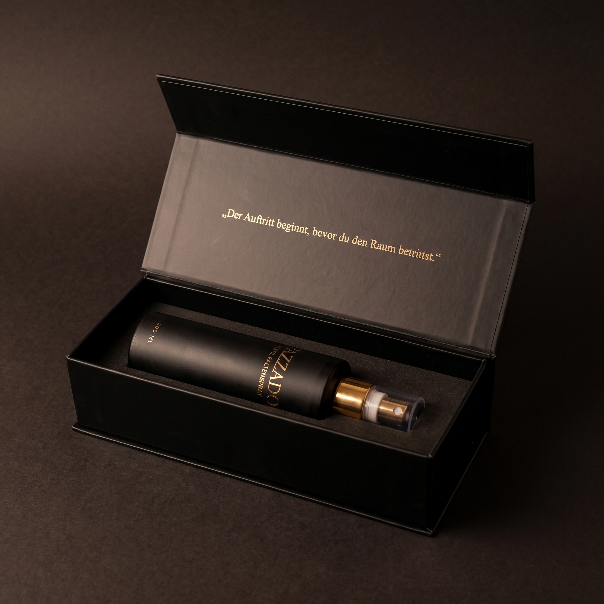 Geöffnete PAZZADO Box: die Flasche liegt mit aufgesetzter Kappe im Schaumstoff, im Deckel steht in Gold „Der Auftritt beginnt, bevor du den Raum betrittst.“